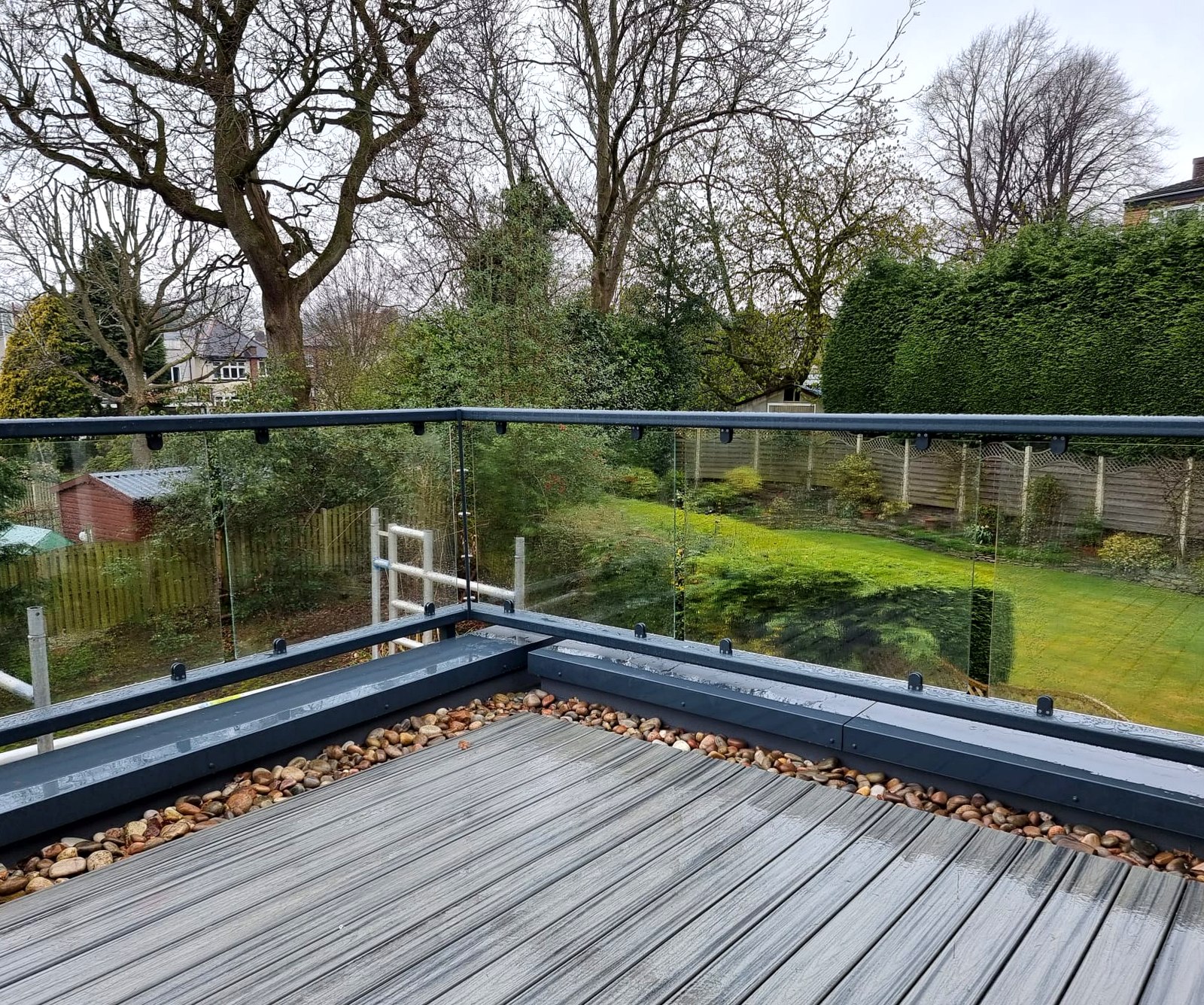 Chunky steel box-section rail and bracketry fixing detail on a cavity-wall glass balustrade, Sheffield